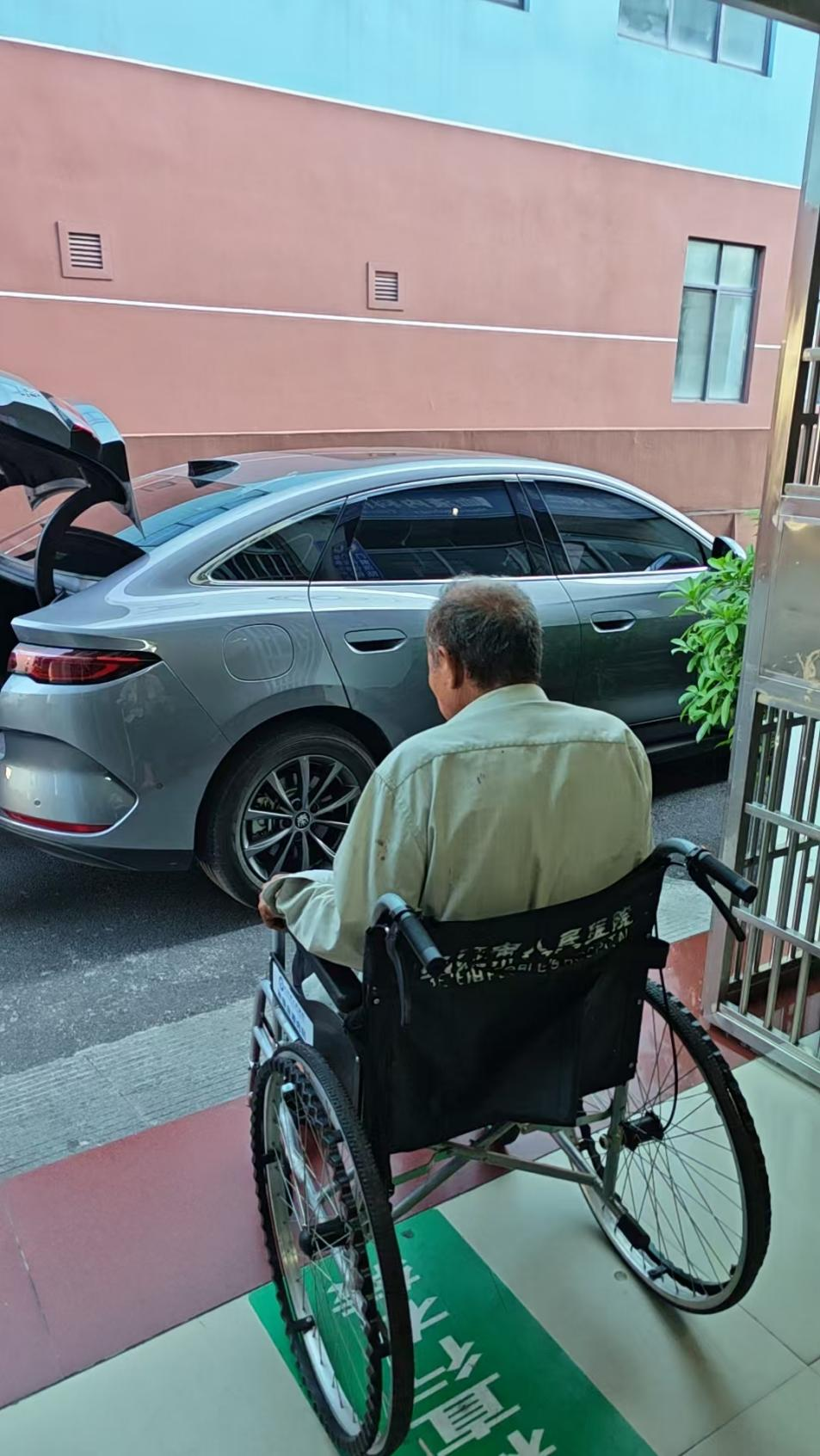 医护人员推轮椅送患者上车